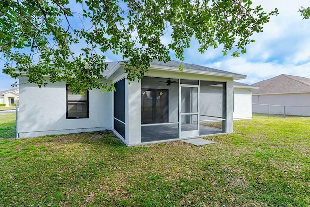 rear view of property with a sunroom, fence, and a yard