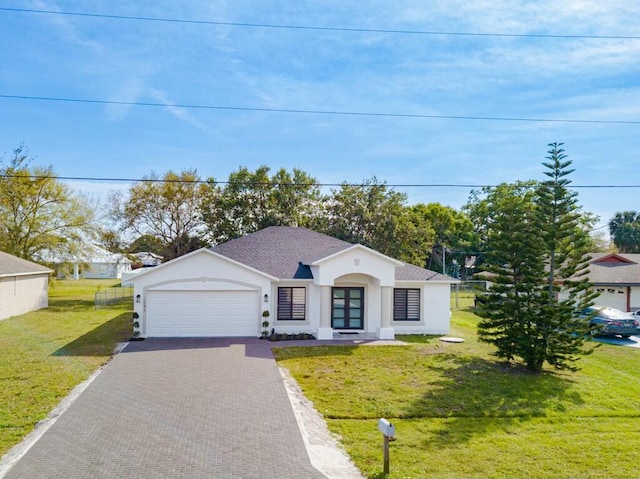 view of front of home featuring a garage, roof with shingles, decorative driveway, stucco siding, and a front yard