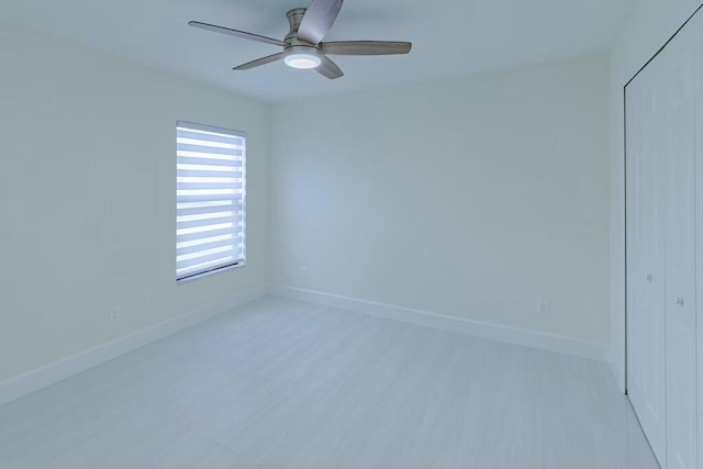 unfurnished room featuring ceiling fan, baseboards, and wood finished floors