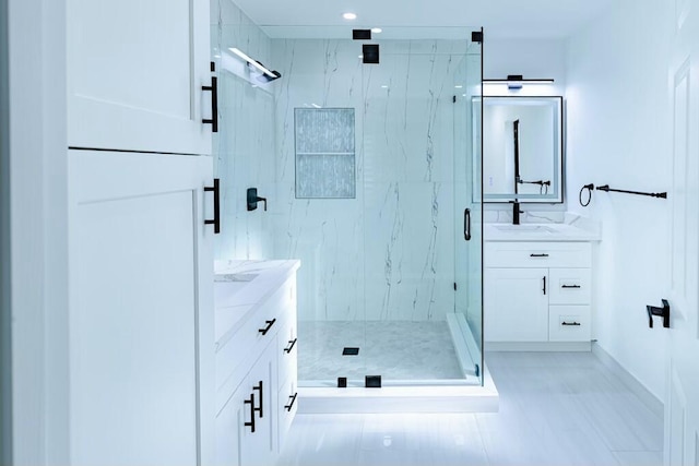 full bathroom with a marble finish shower and vanity