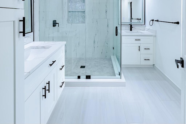 full bath with two vanities, a sink, and a marble finish shower