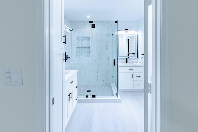 bathroom with a marble finish shower and vanity