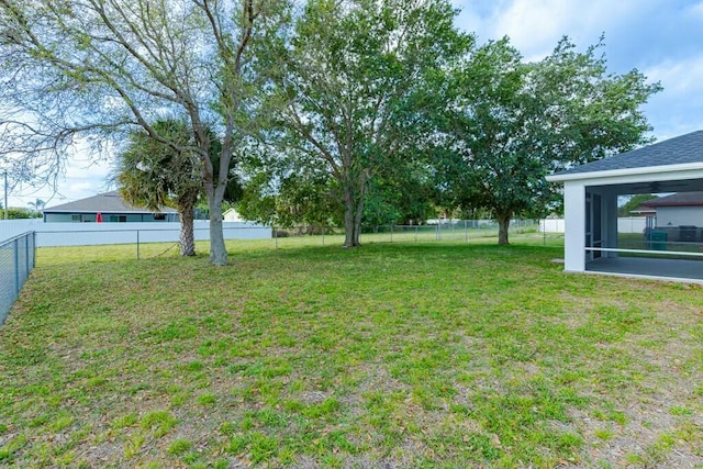 view of yard with a sunroom and a fenced backyard