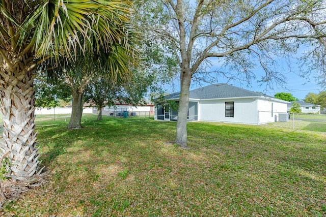 view of yard with central AC unit, a sunroom, and fence