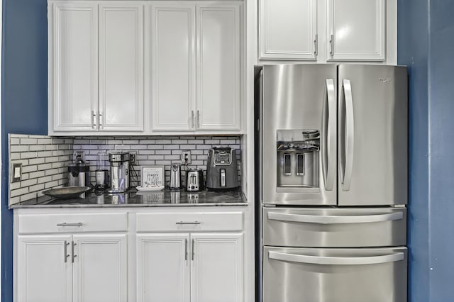 kitchen featuring stainless steel fridge, white cabinets, and decorative backsplash