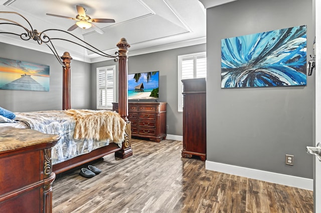 bedroom with ceiling fan, baseboards, a raised ceiling, and wood finished floors