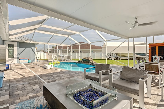 view of swimming pool with ceiling fan, a lanai, fence, a fenced in pool, and a patio area