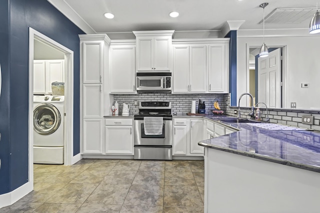 kitchen featuring a sink, white cabinetry, appliances with stainless steel finishes, washer / clothes dryer, and pendant lighting