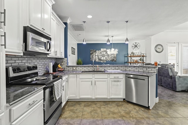 kitchen featuring a peninsula, white cabinets, open floor plan, appliances with stainless steel finishes, and dark countertops