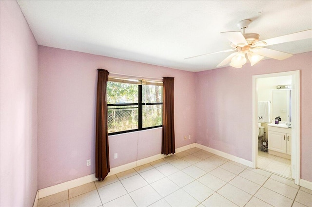 unfurnished room with ceiling fan, baseboards, and light tile patterned floors