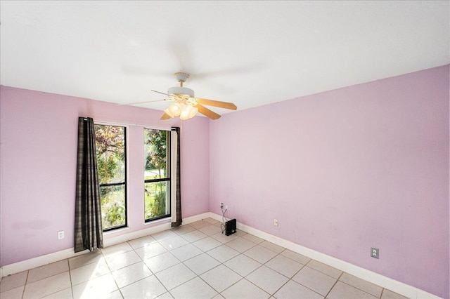 spare room with baseboards, a ceiling fan, and light tile patterned flooring