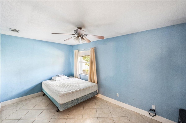 bedroom featuring light tile patterned floors, baseboards, visible vents, and ceiling fan