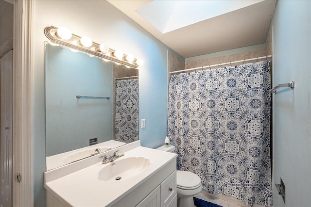 bathroom featuring toilet, curtained shower, a skylight, and vanity