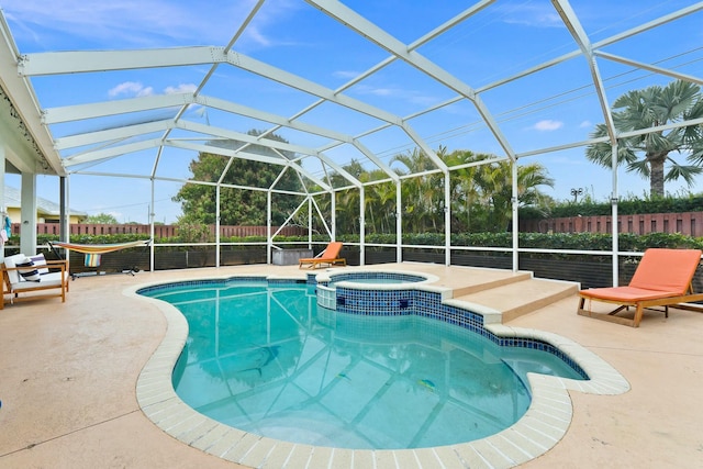 view of pool featuring a fenced backyard, a patio area, glass enclosure, and a pool with connected hot tub