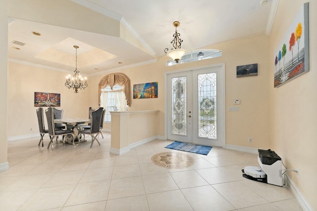 tiled foyer with baseboards, a tray ceiling, a chandelier, and visible vents