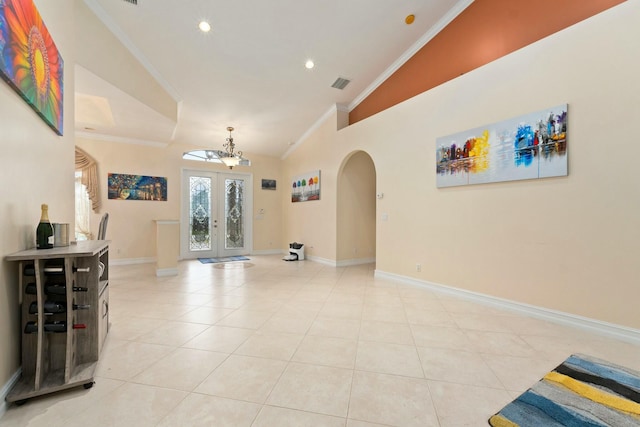 entryway featuring arched walkways, ornamental molding, visible vents, and light tile patterned floors