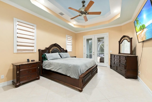 bedroom with french doors, a tray ceiling, visible vents, baseboards, and access to outside