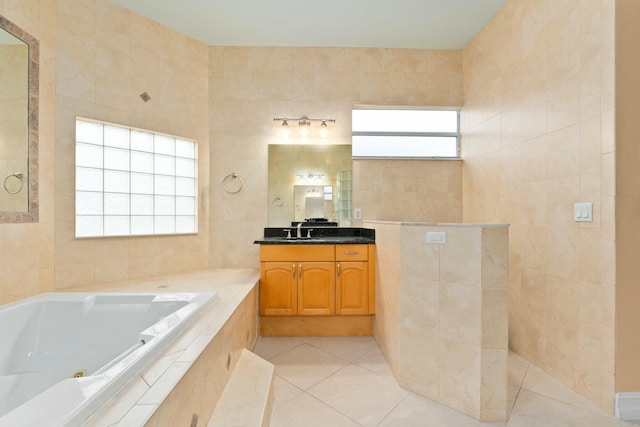 full bathroom with tile walls, vanity, tile patterned flooring, and a jetted tub