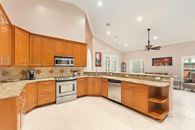 kitchen with stainless steel appliances, a peninsula, a sink, and brown cabinets