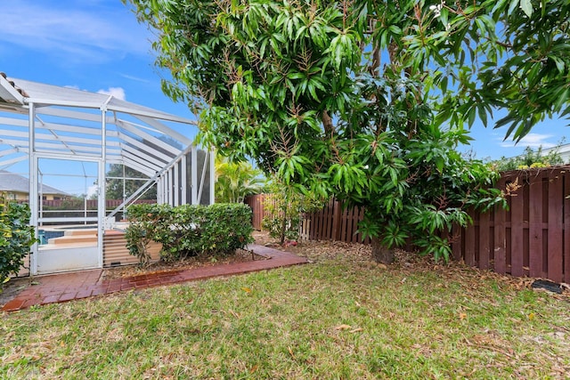 view of yard featuring a lanai and a fenced backyard