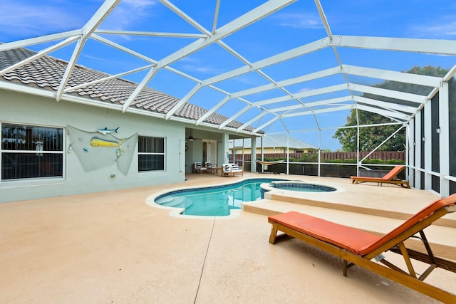 view of swimming pool featuring a patio, a pool with connected hot tub, a ceiling fan, fence, and a lanai