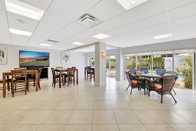 dining room with light tile patterned floors, visible vents, and a drop ceiling