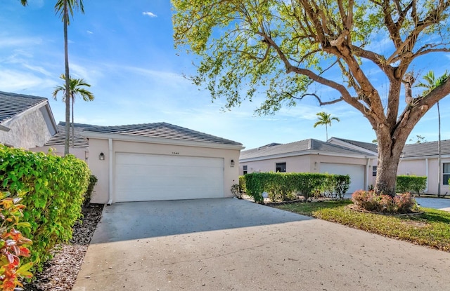 exterior space featuring a garage, concrete driveway, and stucco siding