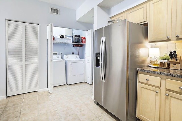 kitchen featuring light tile patterned floors, visible vents, decorative backsplash, stainless steel fridge with ice dispenser, and washing machine and clothes dryer