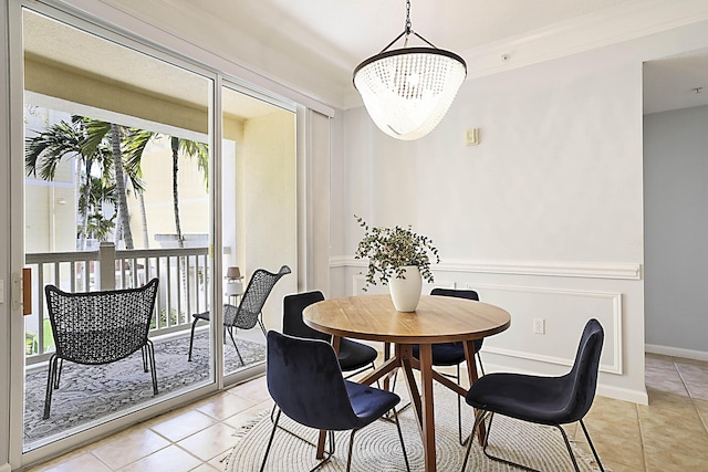 dining room with crown molding, light tile patterned flooring, baseboards, and an inviting chandelier