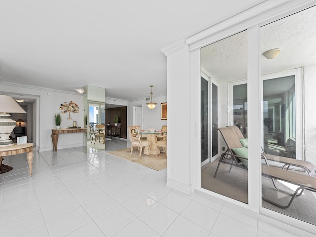 interior space with light tile patterned floors, baseboards, and crown molding