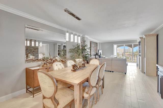 dining area featuring baseboards, light wood-type flooring, and crown molding