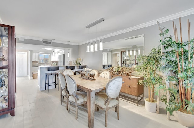 dining space featuring visible vents and crown molding