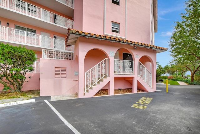 view of building exterior featuring uncovered parking and stairway