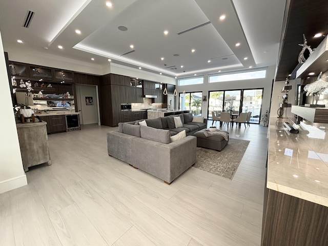 living room featuring a tray ceiling, visible vents, and recessed lighting