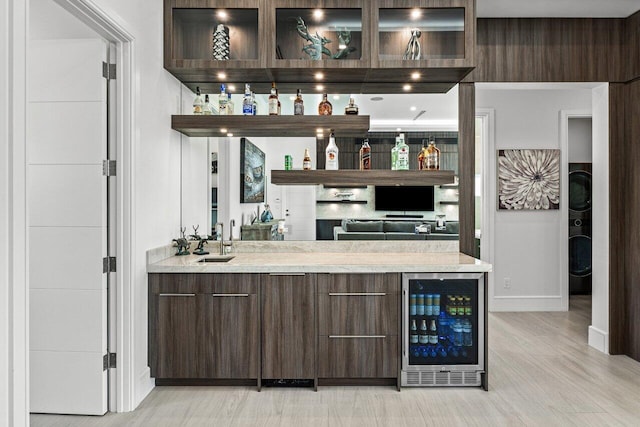 bar featuring wine cooler, indoor wet bar, a sink, and baseboards