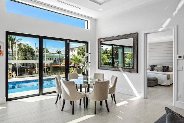 dining room with visible vents, light wood-style flooring, and baseboards