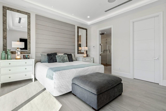 bedroom featuring recessed lighting, light wood-style flooring, baseboards, and ensuite bathroom