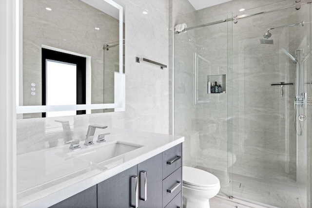 bathroom with tile walls, a marble finish shower, tasteful backsplash, toilet, and vanity