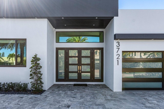 entrance to property featuring french doors and stucco siding