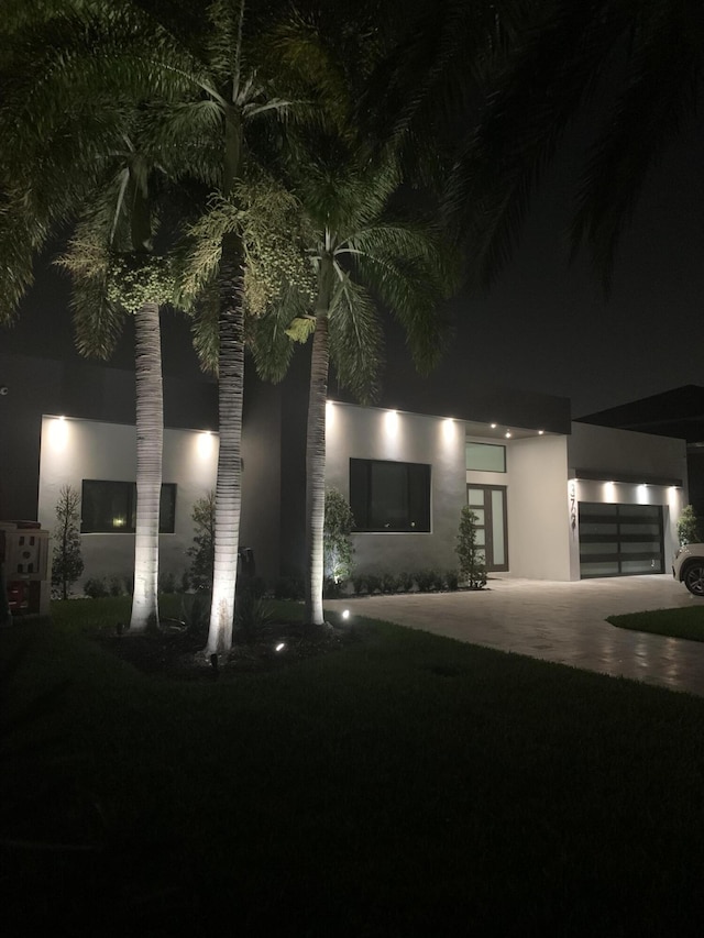 contemporary home with driveway, an attached garage, and stucco siding