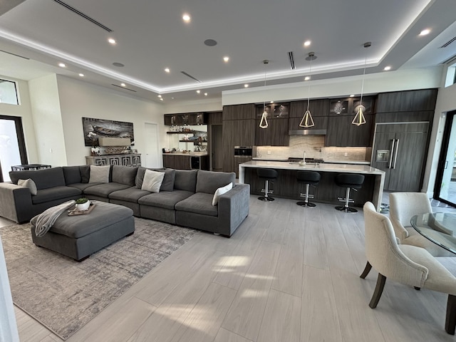 living area featuring recessed lighting and a raised ceiling