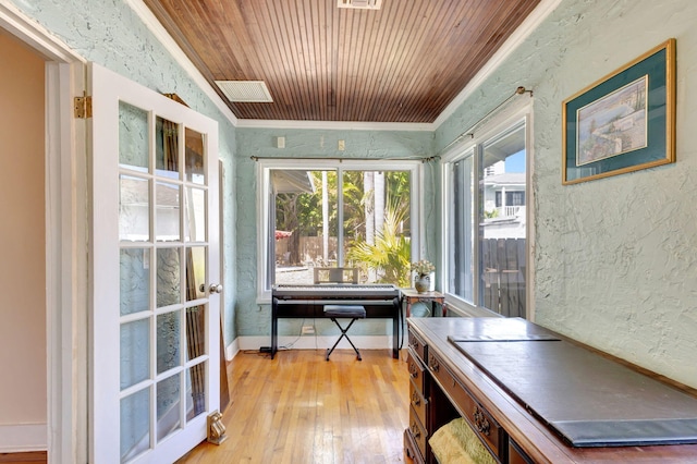 office space featuring visible vents, a textured wall, wooden ceiling, light wood-style flooring, and ornamental molding