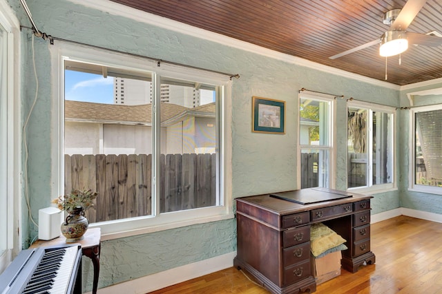 interior space with wood ceiling, a textured wall, baseboards, and wood finished floors