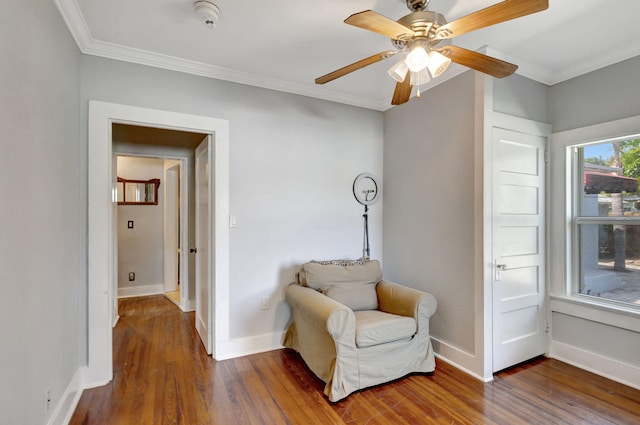 living area featuring crown molding, baseboards, and wood finished floors