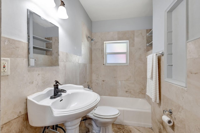 bathroom with tile patterned flooring, toilet, a sink, bathing tub / shower combination, and tile walls