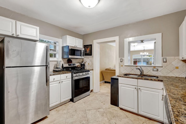 kitchen featuring stainless steel appliances, white cabinets, a healthy amount of sunlight, and a sink