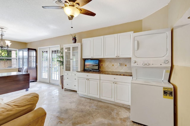 interior space featuring white cabinets, decorative backsplash, french doors, and stacked washer and clothes dryer