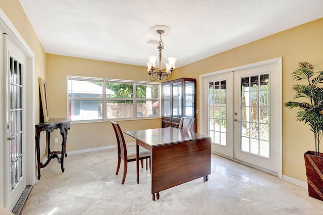 dining space featuring a chandelier, french doors, plenty of natural light, and baseboards