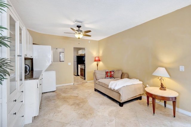 bedroom with a ceiling fan, freestanding refrigerator, visible vents, and baseboards