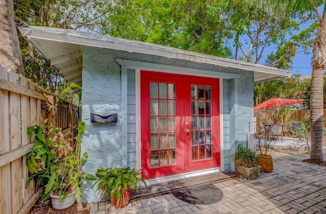 view of outdoor structure featuring french doors, an outdoor structure, and a fenced backyard